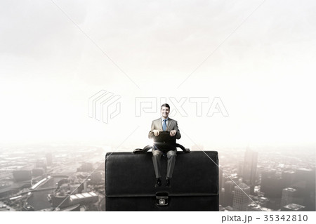 Businessman on big suitcase 35342810