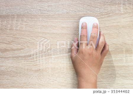 Hand with injury on finger using white computer wireless mouse on wooden background 35344402