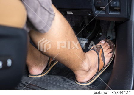 Right foot with flip flop shoe step on the accelerator in the modern car Right foot with flip flop shoe step on the accelerator in the modern car 35344424