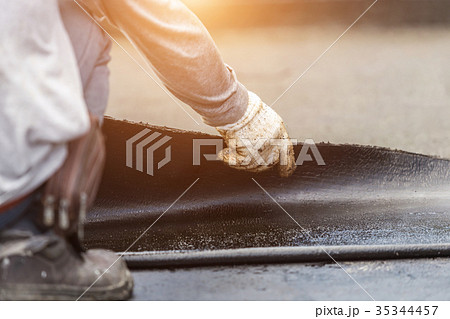 Group of worker installing tar foil on the rooftop of building. Waterproof system by gas and fire torching 35344457