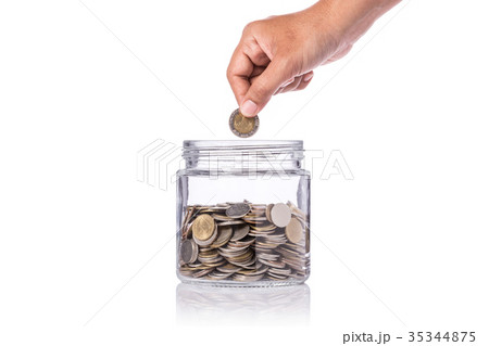 Hand holding Thai coin (baht) and insert to clear glass jar. Studio shot isolated on white. Save money or investment financial for future concept Hand holding Thai coin (baht) and insert to clear glass jar. Studio shot isolated on white. Save money or investment financial for future concept 35344875