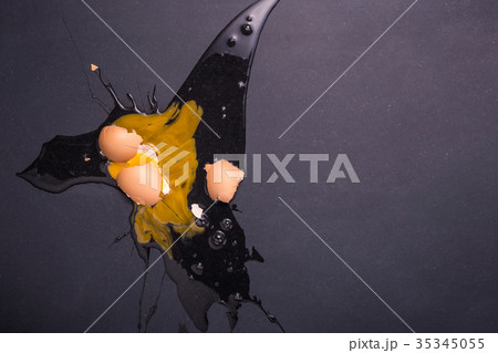 Broken eggs on the black stone ground. Free space for text and design. Top view Broken eggs on the black stone ground. Free space for text and design. Top view 35345055