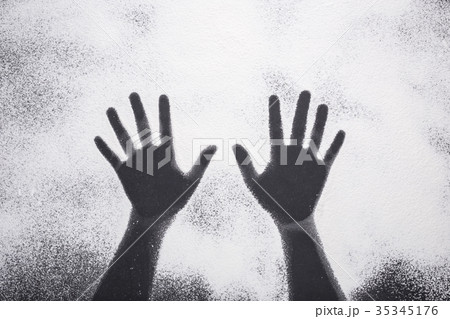 Top view hand prints in flour or white powder on black table 35345176