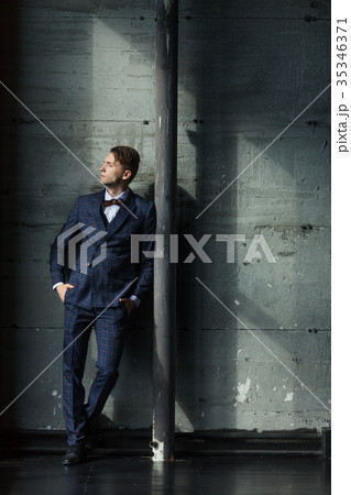 Businessman in a suit is on a grey background Businessman in a suit is on a grey background 35346371
