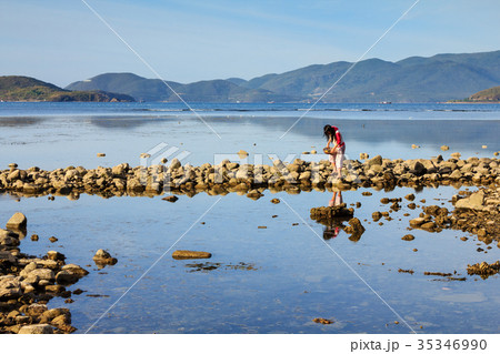 A lady collecting shellfish at a lagoon, Nha Trang 35346990