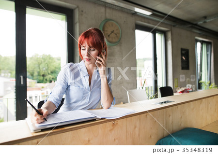 Businesswoman with smartphone in her office. Businesswoman with smartphone in her office. 35348319