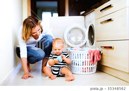 Young mother with a baby boy doing housework. Young mother with a baby boy doing housework. 35348562