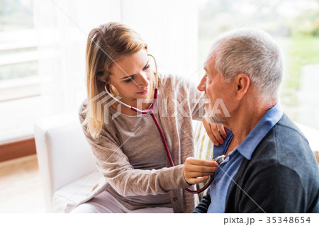 Health visitor and a senior man during home visit. 35348654