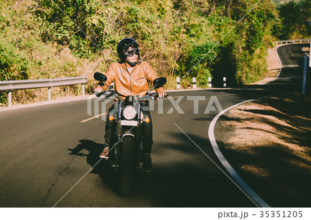 man riding motorbike on a road man riding motorbike on a road 35351205