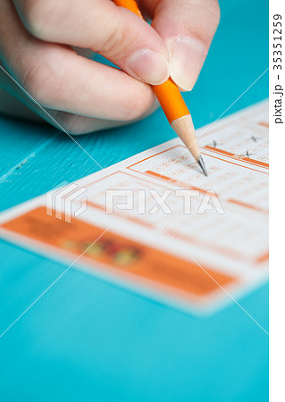 Picture of man's hand with pencil and lottery Picture of man's hand with pencil and lottery 35351259