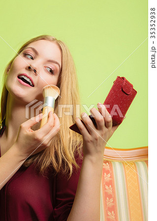 Attractive woman applying make up with brush. Attractive woman applying make up with brush. 35352938