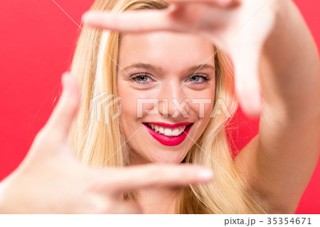 Young woman framing her face with her fingers  35354671
