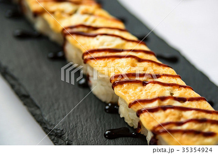 Freshly cooked uncut sushi roll on black board 35354924