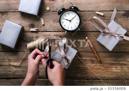 Beautiful woman hands holding gift box on wooden Beautiful woman hands holding gift box on wooden 35356009