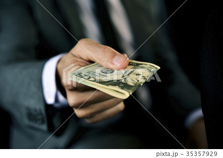 man with a wad of dollar bills in a car man with a wad of dollar bills in a car 35357929