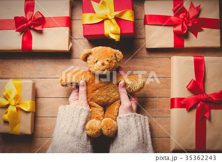 Woman hands holding teddy bear toy with gifts 35362243