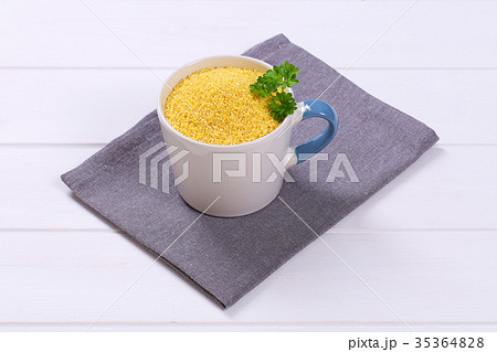 mug of raw millet grains 35364828