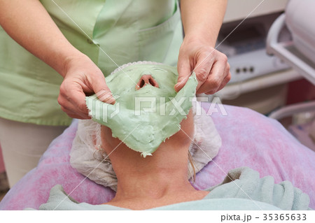 Cosmetician removing facial mask. Cosmetician removing facial mask. 35365633