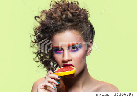 Makeup model biting grapefruit slice. 35366295