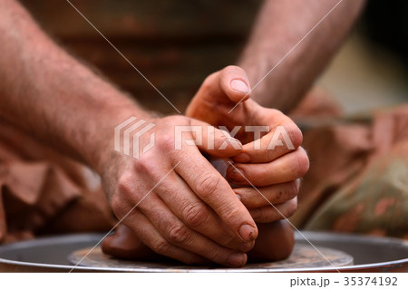 Potter making ceramic pot on the pottery wheel 35374192