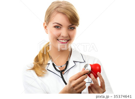 Woman doctor with stethoscope examining red heart 35374641