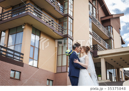 newlywed couple hugging and kissing against 35375848