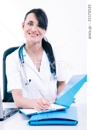 Female doctor sitting at office desk and smiling Female doctor sitting at office desk and smiling 35378585