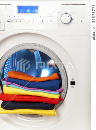 The washing machine with an open door and linen.. The washing machine with an open door and linen.. 35378775