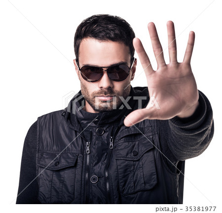 Handsome man in sunglasses shows stop signal 35381977