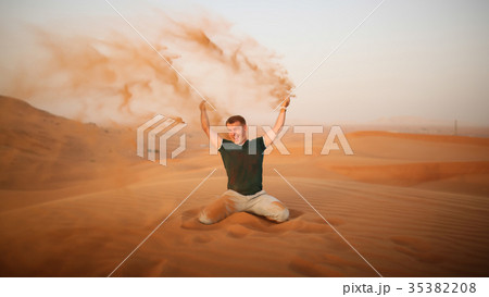 The guy throws sand over himself in the desert 35382208