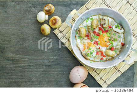 Egg frying pan and mushrooms on wood. 35386494