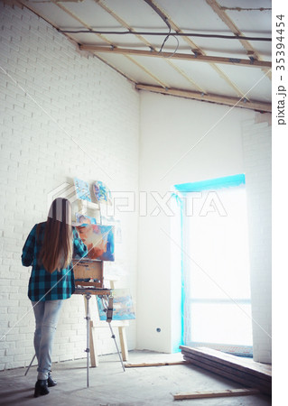 Young artist girl at work in the workshop brush paints canvas inspiration 35394454
