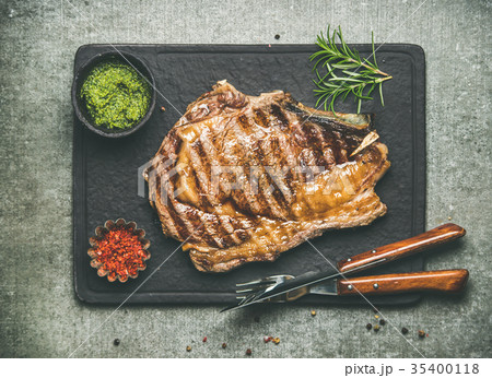 Grilled hot rib-eye beef steak on bone with 35400118