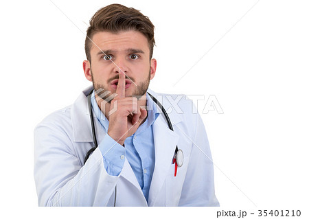 A handsome doctor gesturing silence with his A handsome doctor gesturing silence with his 35401210