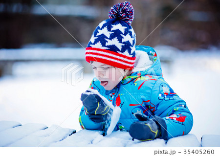 Happy kid boy having fun with snow in winter 35405260