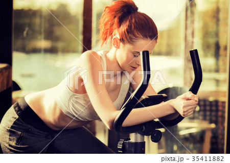 Active young woman doing exercise on bicycle 35411882