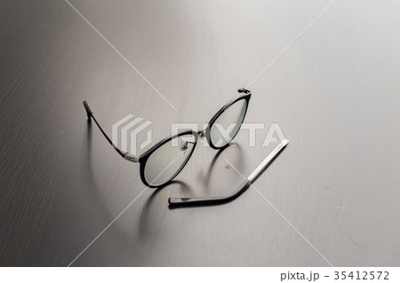 Old black glasses with broken legs. 35412572