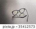 Old black glasses with broken legs. 35412573