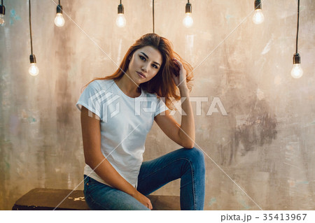 Sexy woman in a white T-shirt on a gray background Sexy woman in a white T-shirt on a gray background 35413967