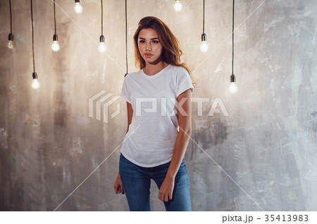 Sexy woman in a white T-shirt on a gray background Sexy woman in a white T-shirt on a gray background 35413983