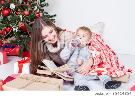 mother reading a book to a child at Christmas new mother reading a book to a child at Christmas new 35414854
