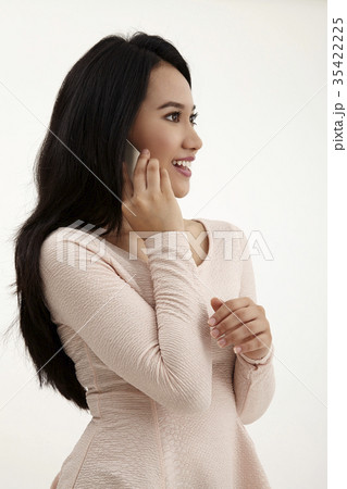 Asian woman talking on mobile phone Asian woman talking on mobile phone 35422225