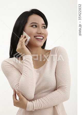 Asian woman talking on mobile phone Asian woman talking on mobile phone 35422832