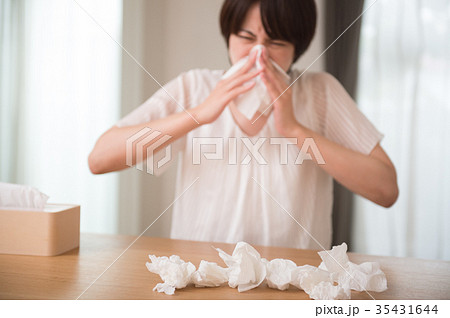 鼻をかむ女性 花粉症 風邪 ティッシュの写真素材