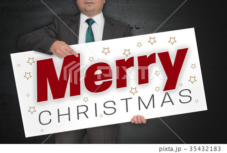 Merry Christmas poster is held by businessman Merry Christmas poster is held by businessman 35432183