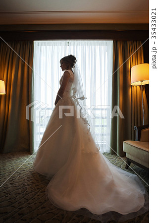 Attractive stylish brunette bride near a window in 35433021