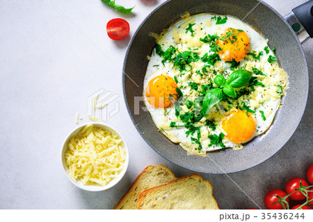 Fried eggs in pan, herbs, spices, cherry tomatoes Fried eggs in pan, herbs, spices, cherry tomatoes 35436244