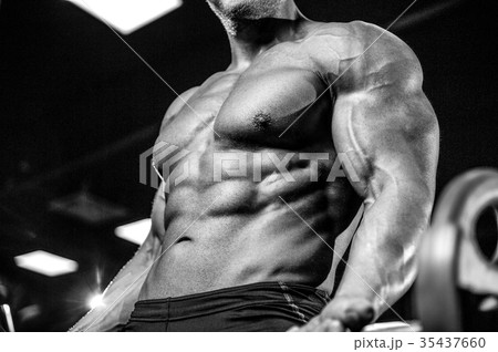 Handsome model young man training arms in gym Handsome model young man training arms in gym 35437660