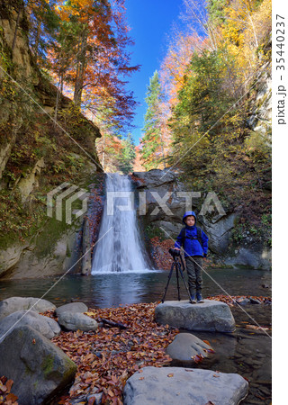 Kid with photo camera on tripod with a waterfall 35440237