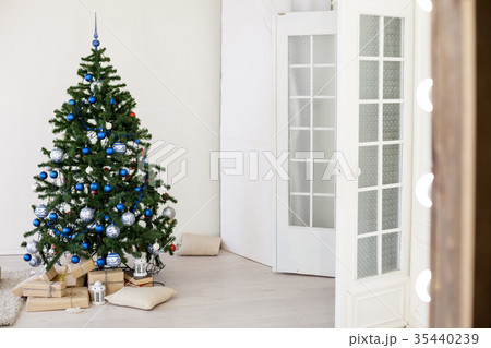 Christmas tree with blue in a white room with toys Christmas tree with blue in a white room with toys 35440239